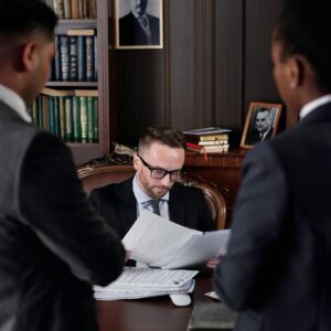 Business professionals discussing important legal documents in an office setting.