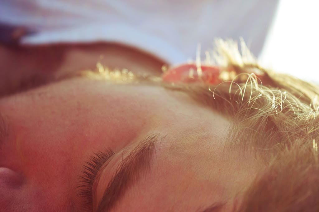 A serene close-up of a man sleeping in soft sunlight, capturing peaceful tranquility.