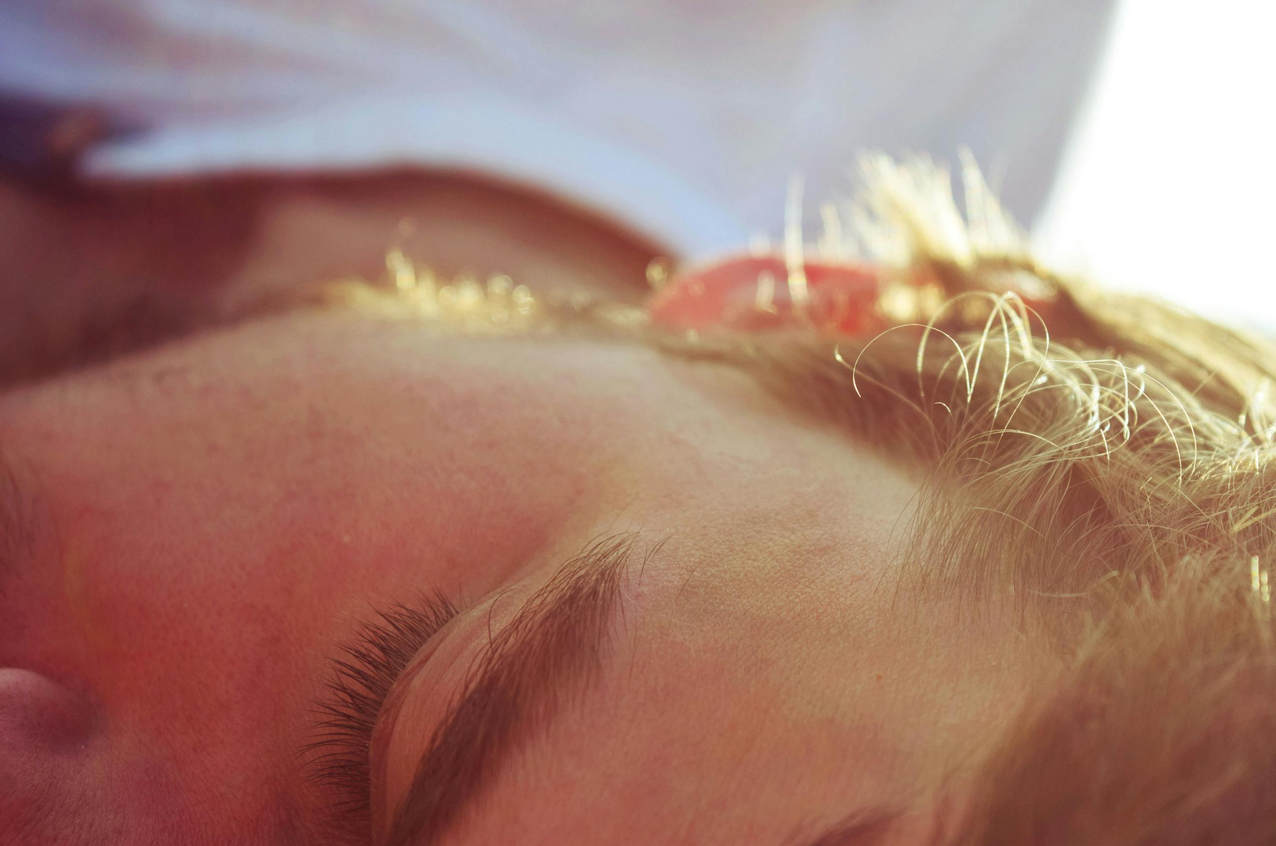 A serene close-up of a man sleeping in soft sunlight, capturing peaceful tranquility.