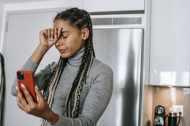 African American woman feeling stressed during a video call at home.