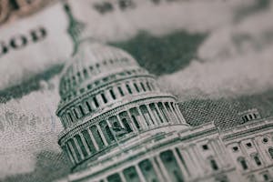 Close-up of the US Capitol illustration on American currency, showing detailed architectural design.