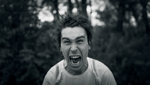 Intense black and white portrait showcasing a man yelling with a furious expression.