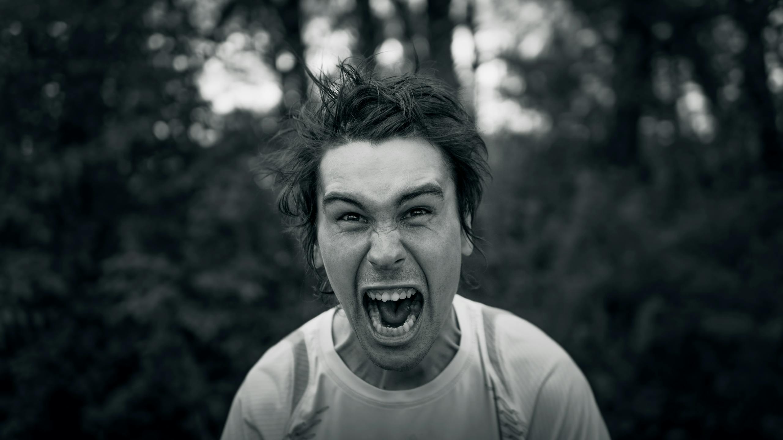 Intense black and white portrait showcasing a man yelling with a furious expression.