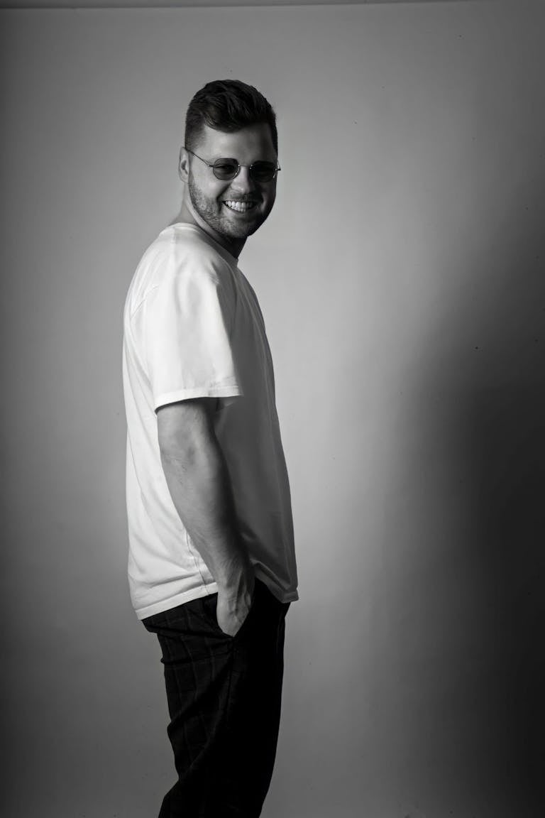 Monochrome portrait of a smiling man in casual attire. Stylish and timeless.