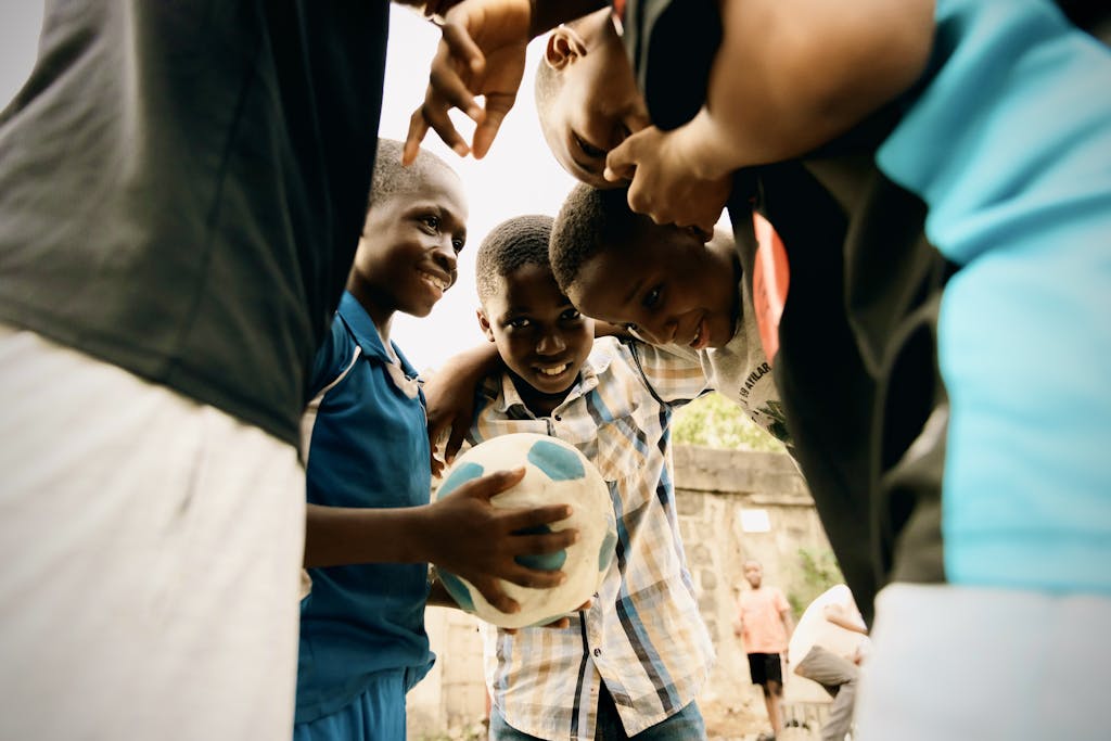 Group of boys enjoying a soccer game outdoors in Lagos, Nigeria. Monkey Post.
