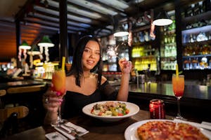 Woman celebrating with sparklers and cocktails in a cozy Istanbul bar.